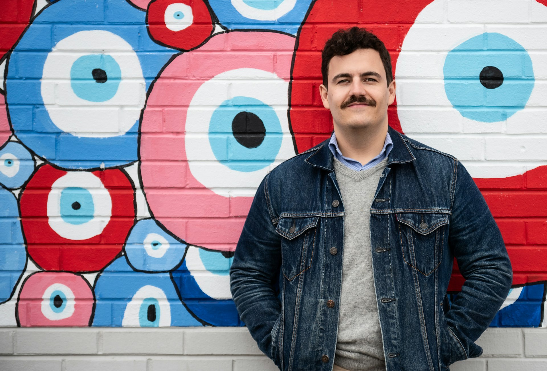 Joe Schiarizzi standing in front of a colorful mural